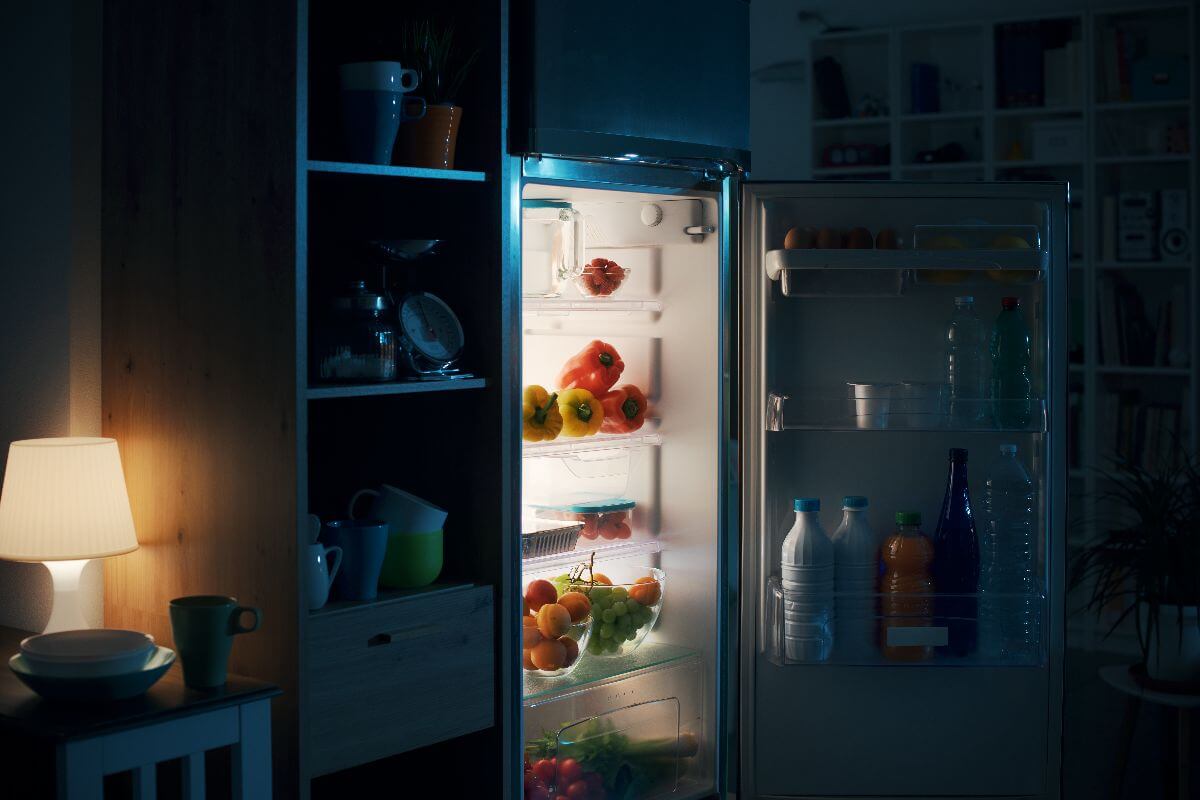 full refrigerator opened in a dark room