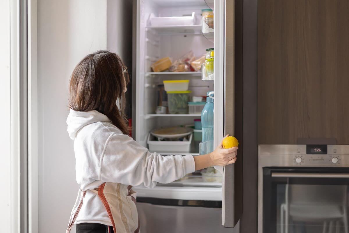 woman opening silver refrigerator
