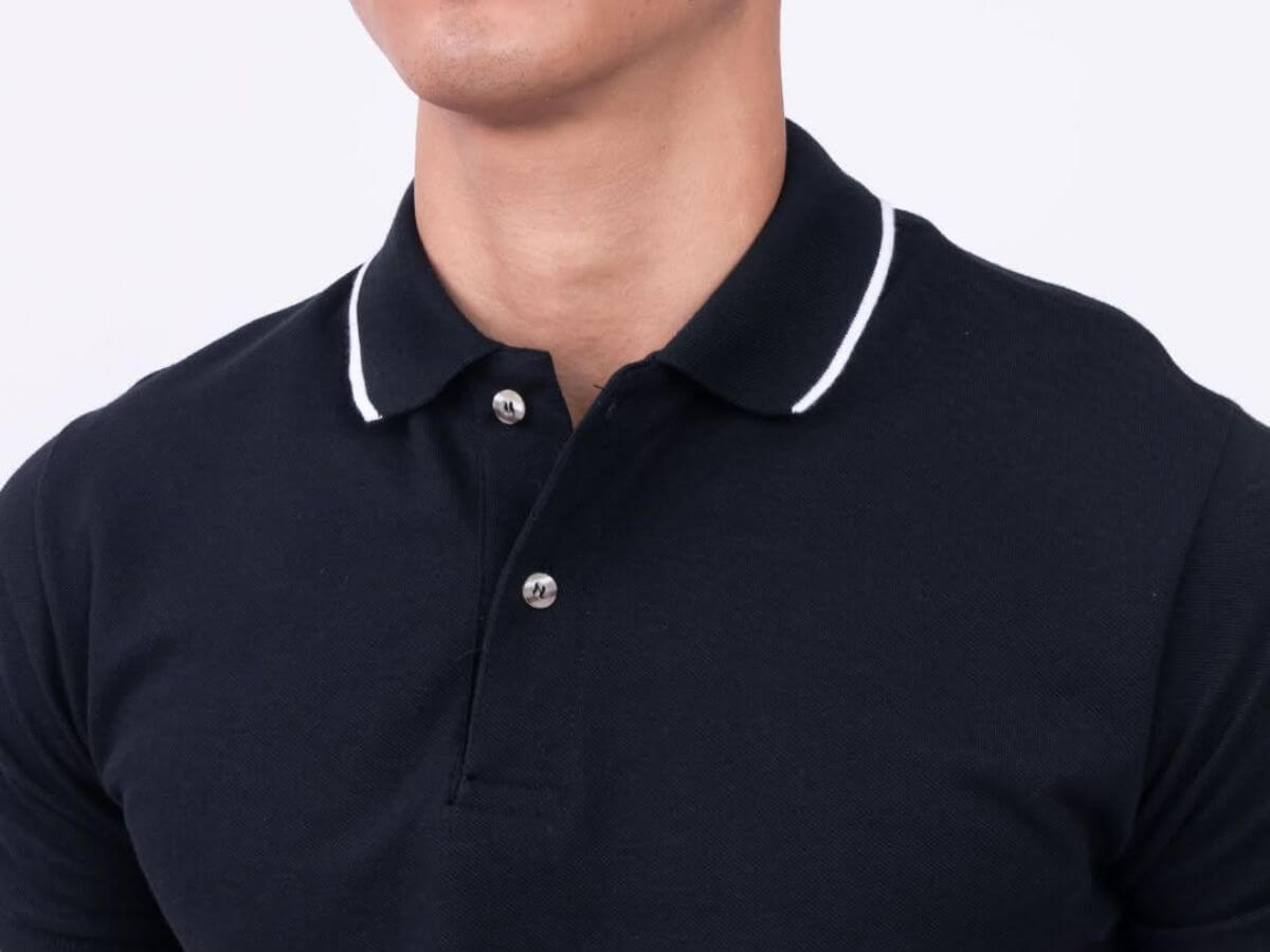 Man wearing a black lined polo shirt, styled for a clean, modern look suitable for casual and semi-formal occasions.