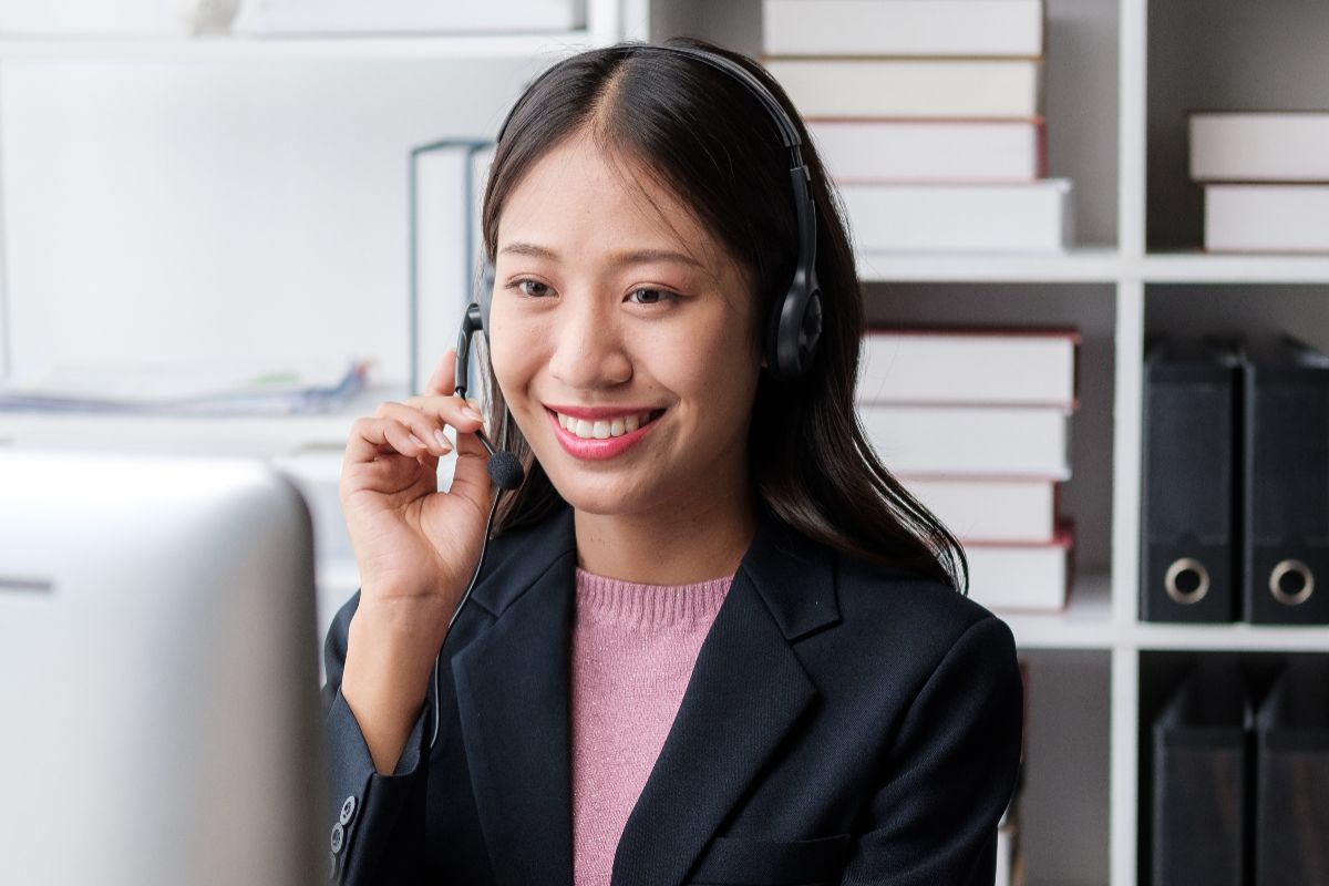 Smiling virtual assistant using a headset in a home office setting