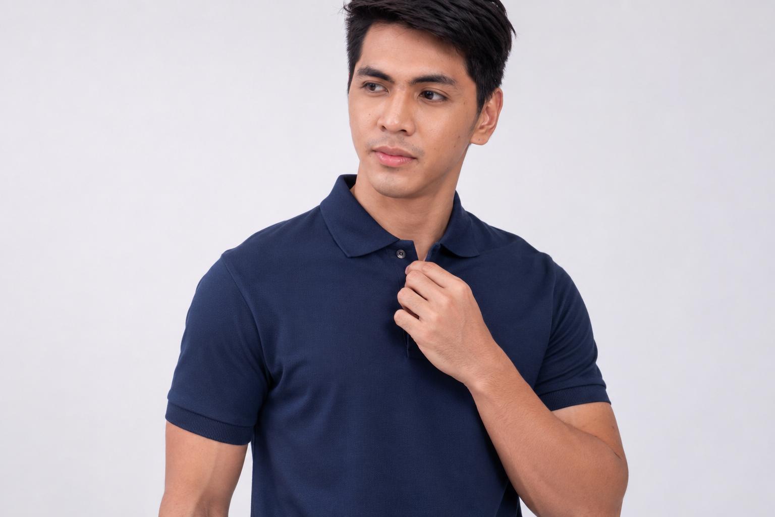 Male model wearing a navy blue polo shirt against a light studio background.