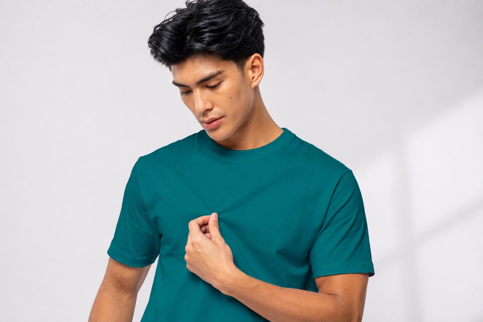 Male model wearing a teal plain shirt against a light studio background.