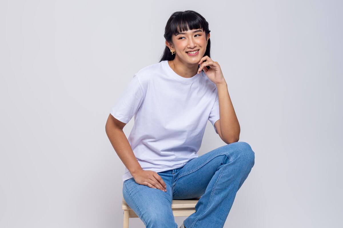 Female model wearing a white plain round neck shirt with denim jeans