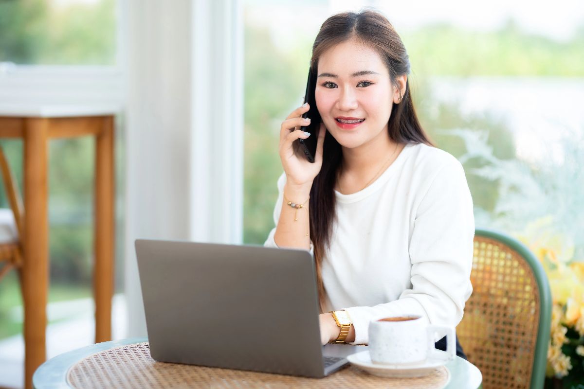 Virtual assistant speaking on the phone while working on a laptop from home