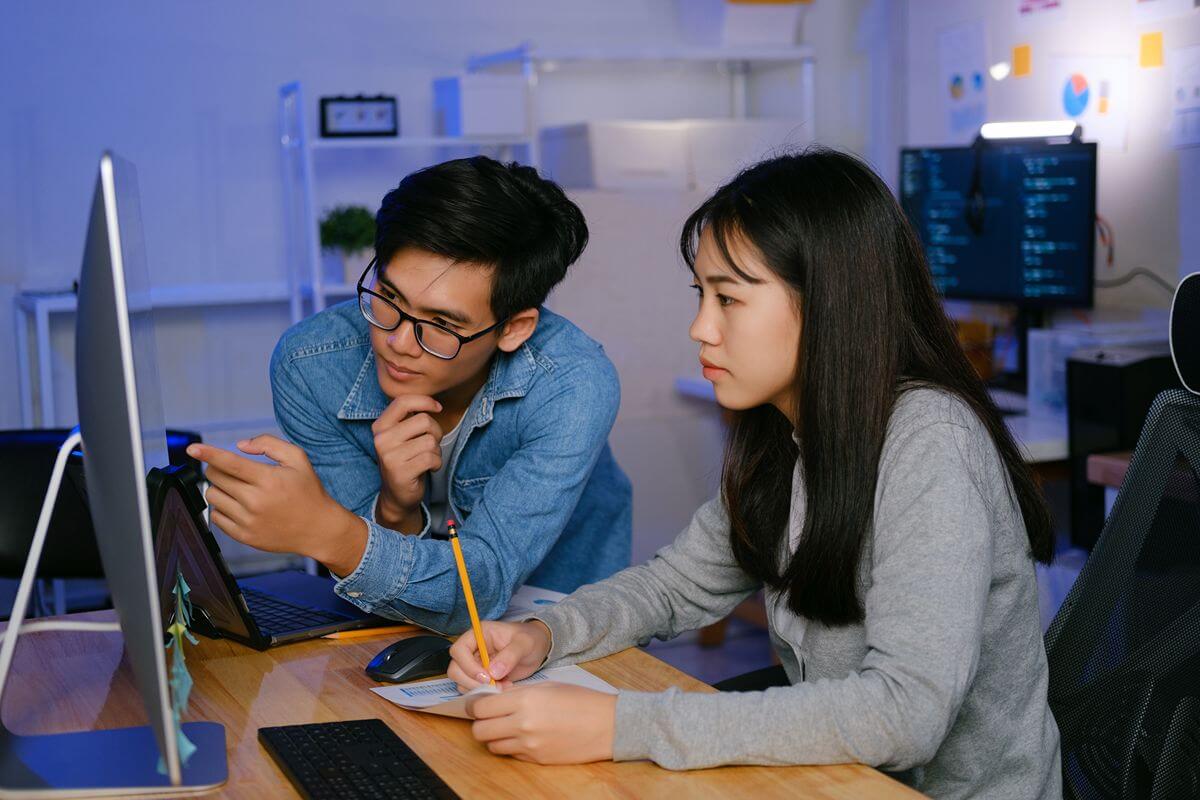 Students review digital design work together in a computer lab