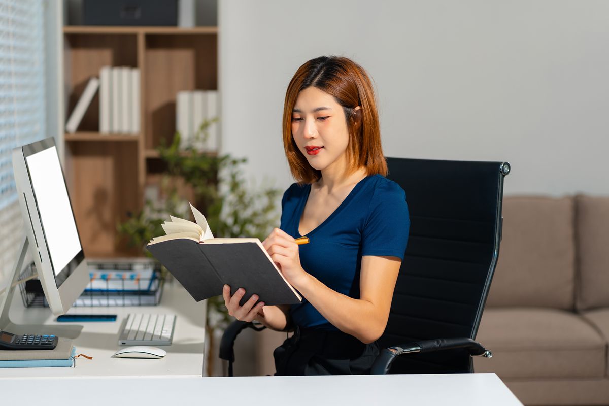 Philippine virtual assistant reviewing notes while managing administrative and support tasks at a desk