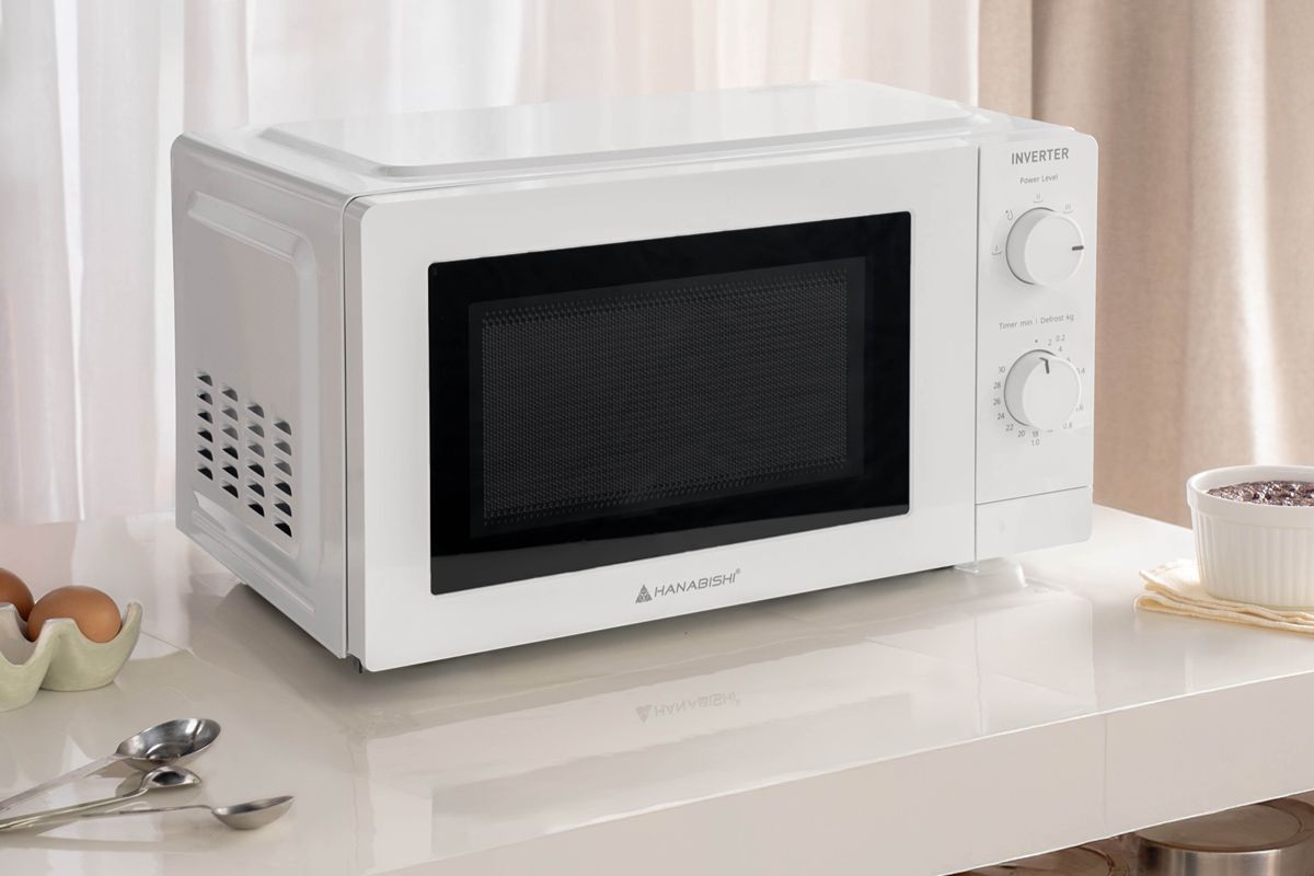 White Hanabishi microwave oven displayed on a clean kitchen countertop