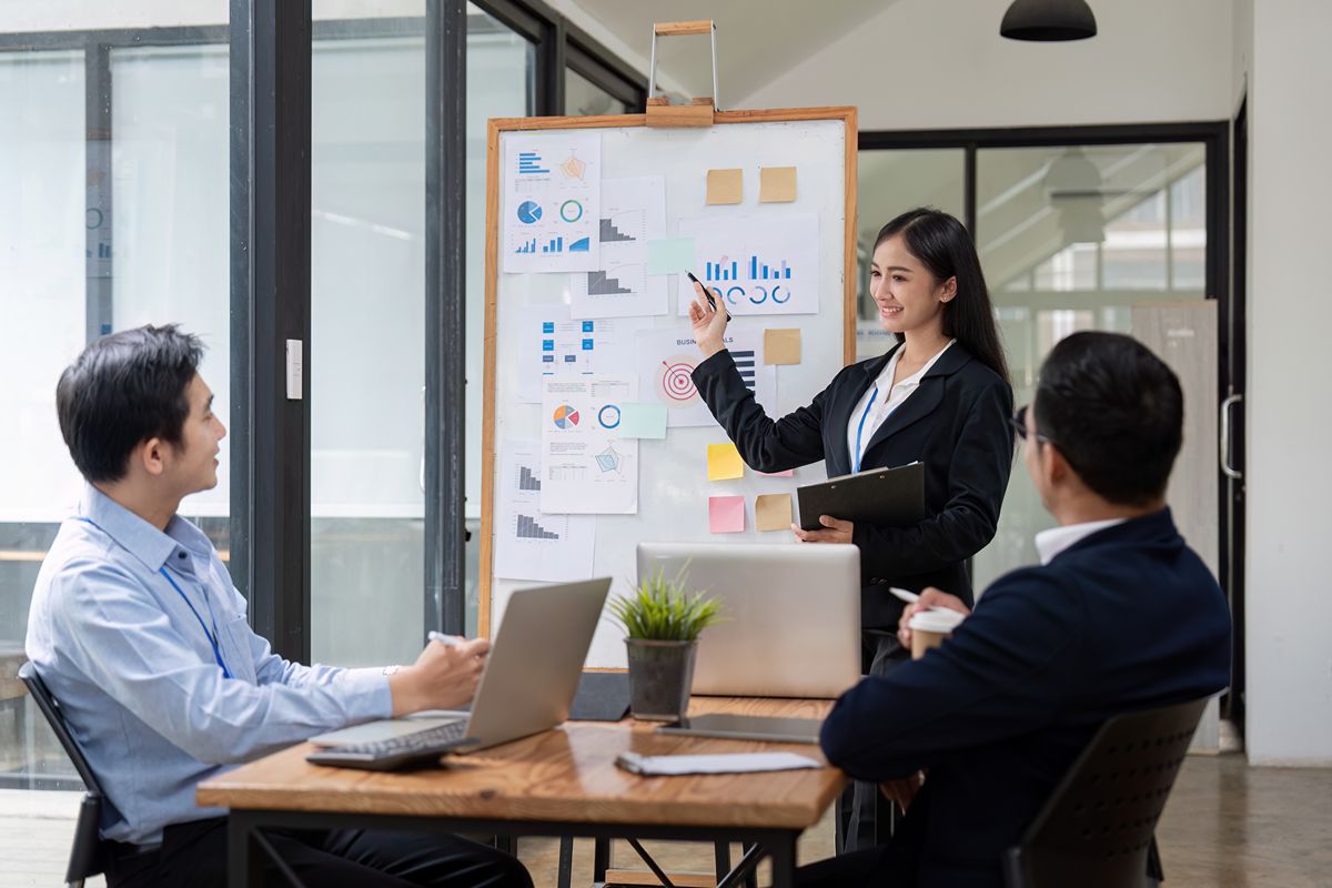 Business professional presenting social media performance charts to colleagues during a strategy meeting