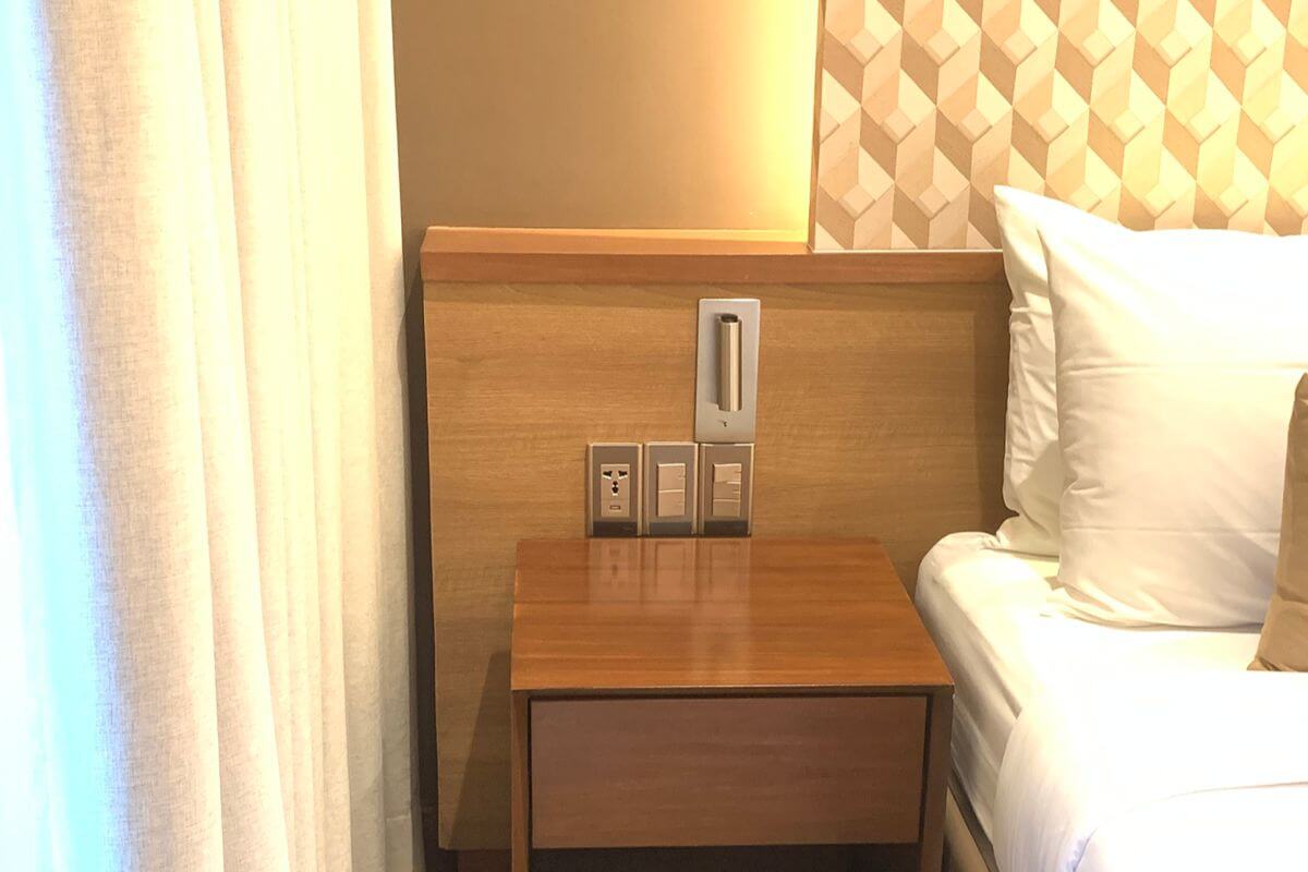 Bedside switches and outlets installed for convenient lighting control and power access in a bedroom