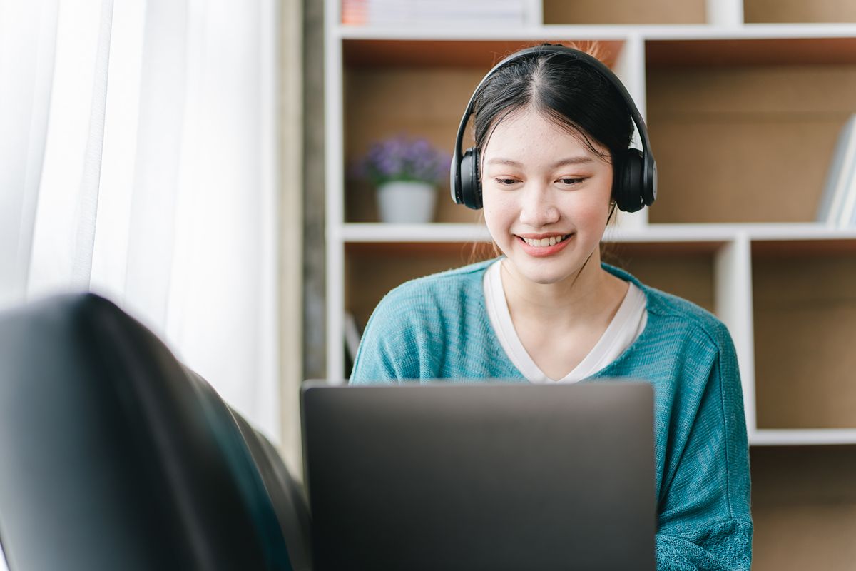 Healthcare virtual assistant wearing headphones while working remotely for a VA agency